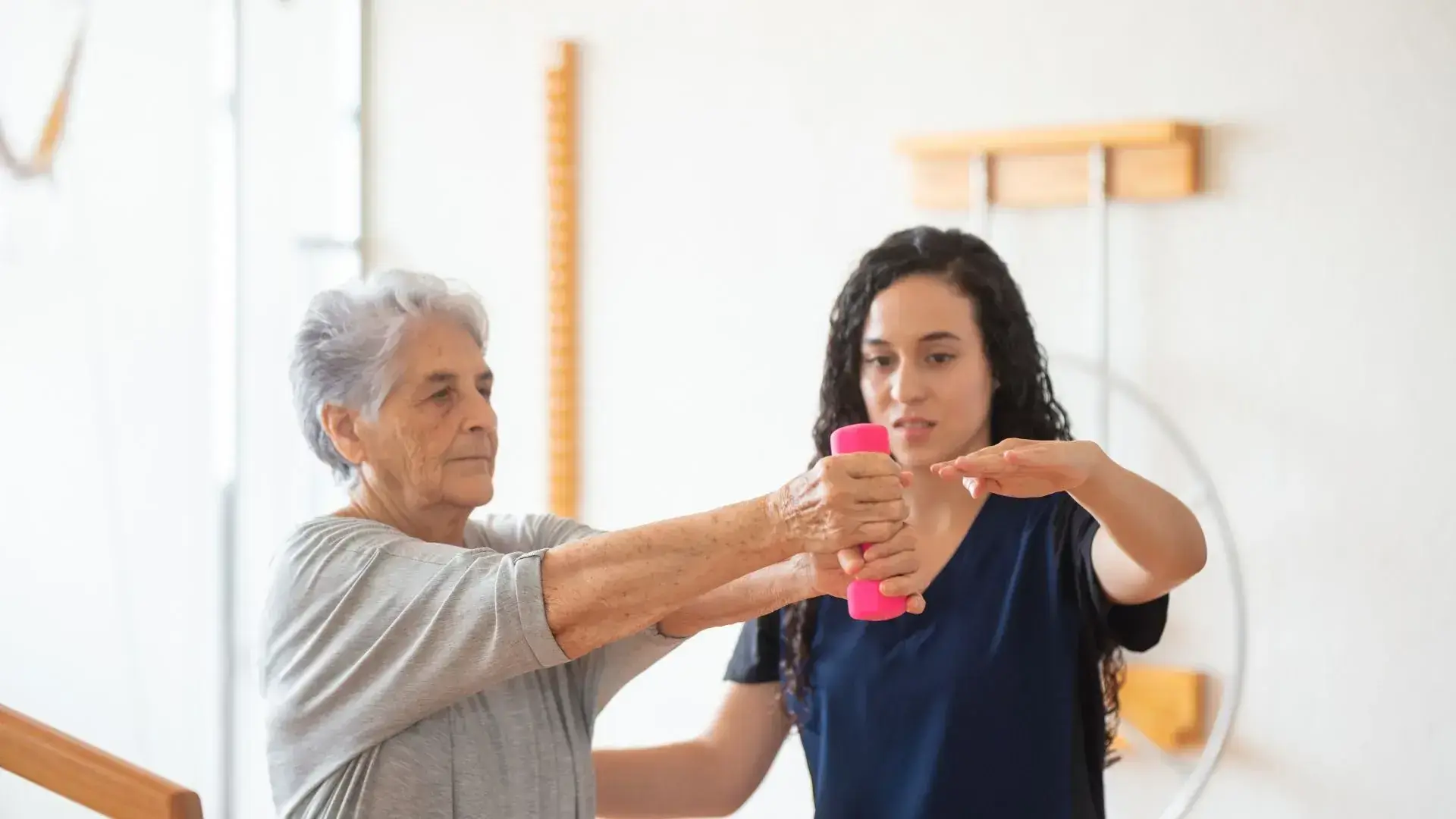 Senior woman in athletic wear performing stretching exercise during physiotherapy recovery session